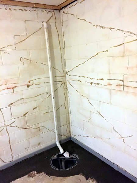 A sump pump is installed in the corner of a basement. BDB Waterproofing can help install your sump pump