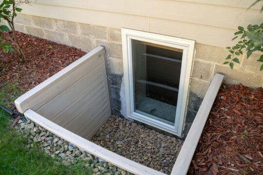 An egress window is set up in a basement and includes a window well.