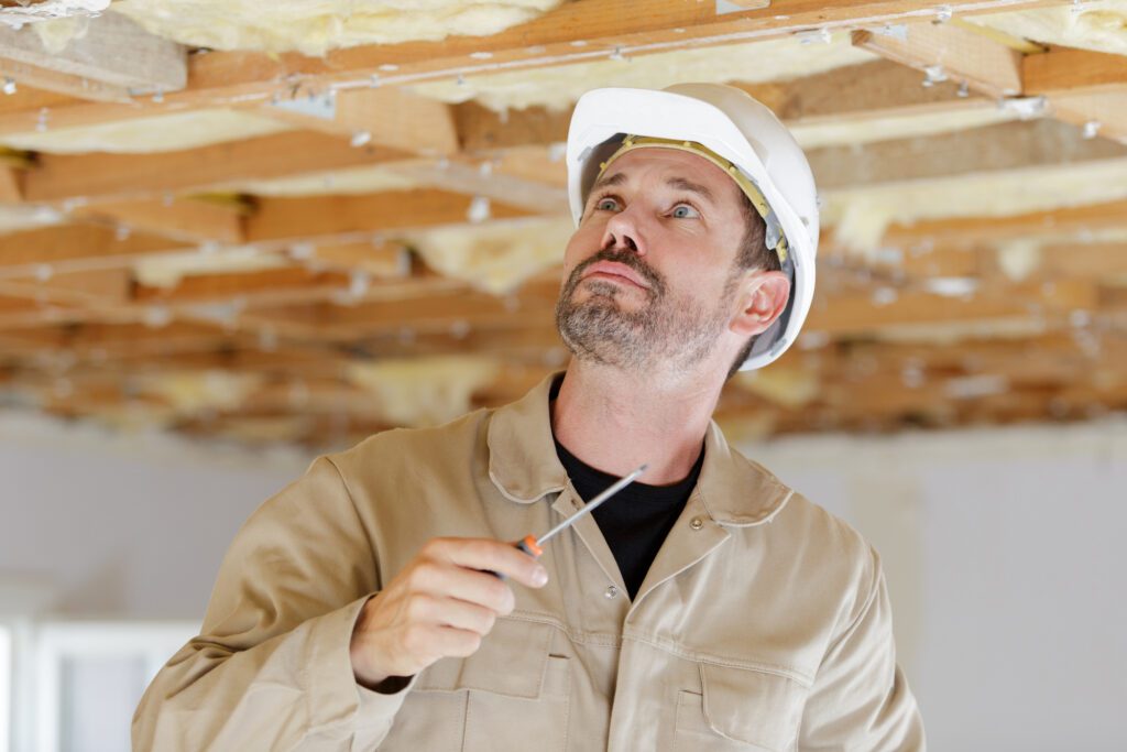 A contractor looks at a basement foundation to see what is wrong with it.